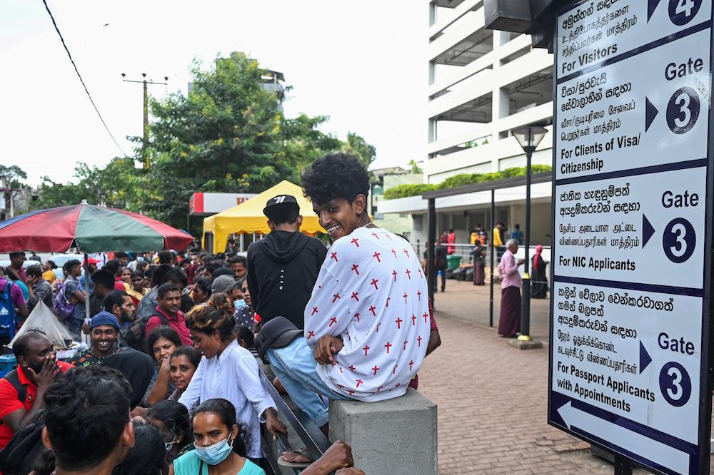 Above, people gather in front of the Department of Immigration and Emigration in Colombo on July 18, 2022. Sri Lanka’s immigration chief was the latest top official jailed under the government’s anti-corruption drive. (AFP file photo)