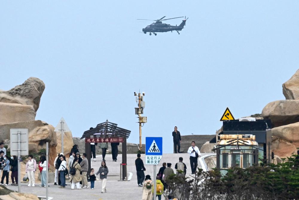 Above, a Chinese military helicopter flies past at a viewing point over the Taiwan Strait on Pingtan, the closest point to Taiwan, in China’s southeast Fujian province on April 7, 2023. (AFP)