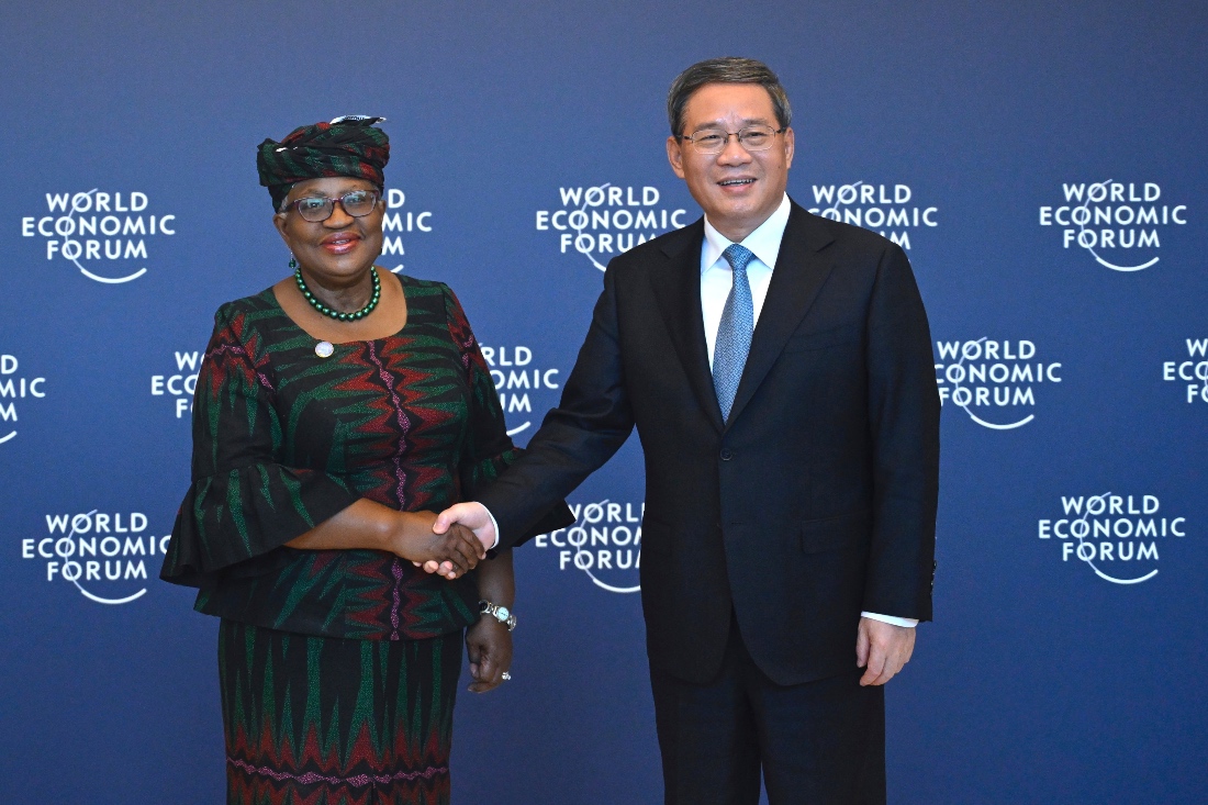 Chinese Premier Li Qiang, right, shakes hands with Director-General of the World Trade Organization Ngozi Okonjo-Iweala, in Tianjin. (AP)
