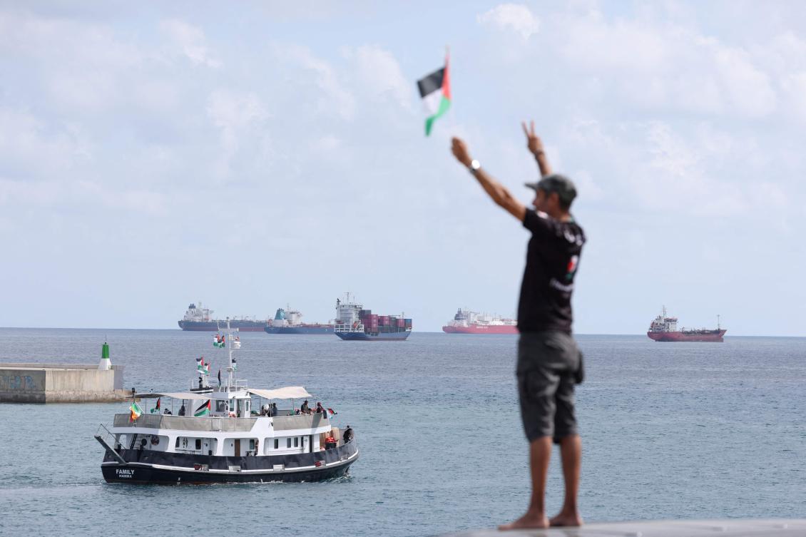 An activist waves the Palestinian flag as a boat from the Global Sumud Flotilla leaves the port of Barcelona, Aug. 31, 2025. (AFP)