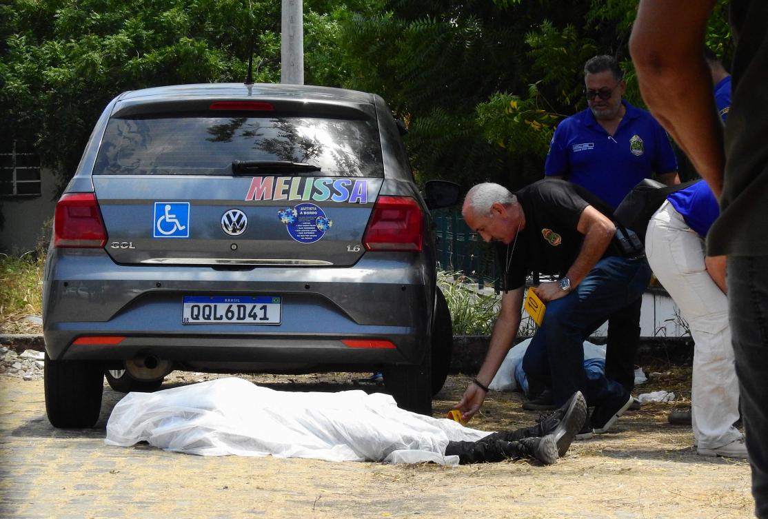 Ceara’s civil police officers check the bodies of two teenagers killed in a shooting inside a public school parking lot in Sobral, Ceara state, Brazil on Sept. 25, 2025. (AFP)