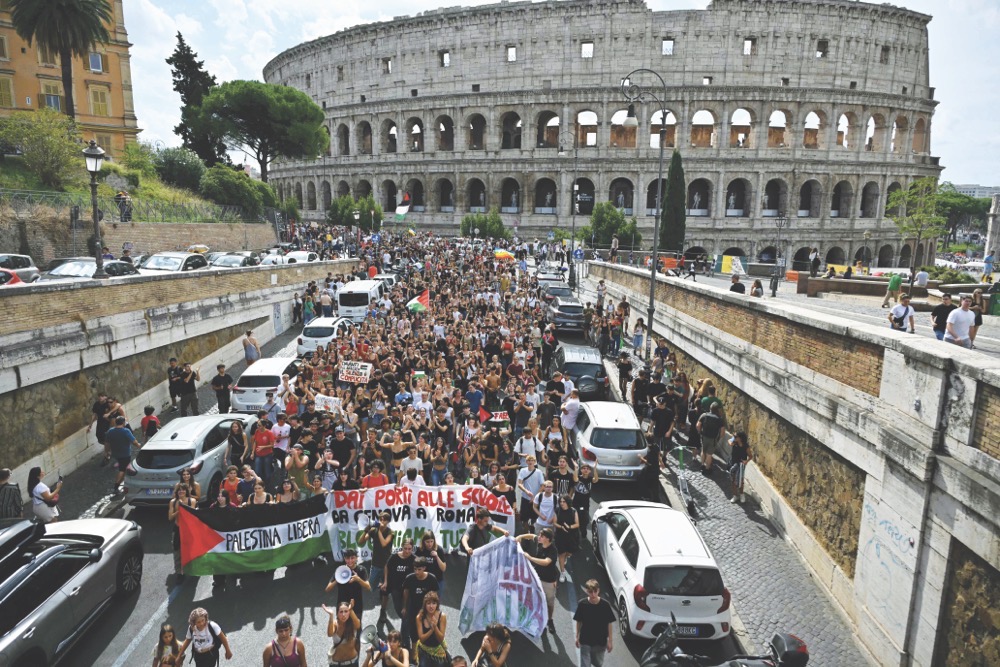 People stage a demonstration in Rome during a nationwide strike in solidarity with Palestinians in Gaza and calling for a halt to arms shipments to Israel. (AFP)