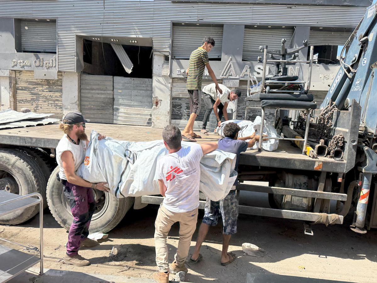 MSF staff load tents and other goods on to a truck outside one of their clinics in Gaza City as they pull out from the area amid Israeli's onslaught. (MSF)
