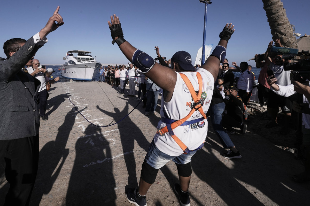 Egyptian wrestler Ashraf Mahrous pulling a 700-ton ship across the water with a rope held only by his teeth, at the marina in the Red Sea resort of Hurghada, Egypt, on Sept. 27, 2025. (AP Photo/Amr Nabil)