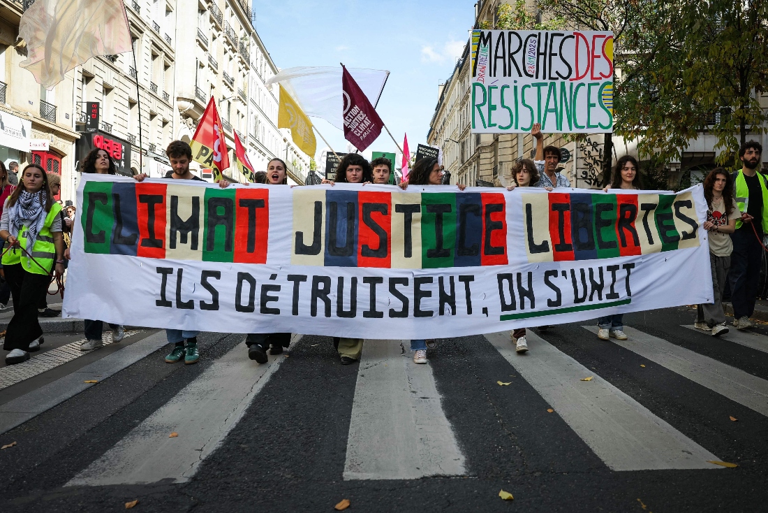 Protesters hold a banner reading "Climat, Justice, Freedom, they destroy us, we come together" as they march during a demonstration to protest against the Duplomb law, the implementation of the Zucman tax, and an embargo on arms sales to Israel, in Paris, France. (AFP)