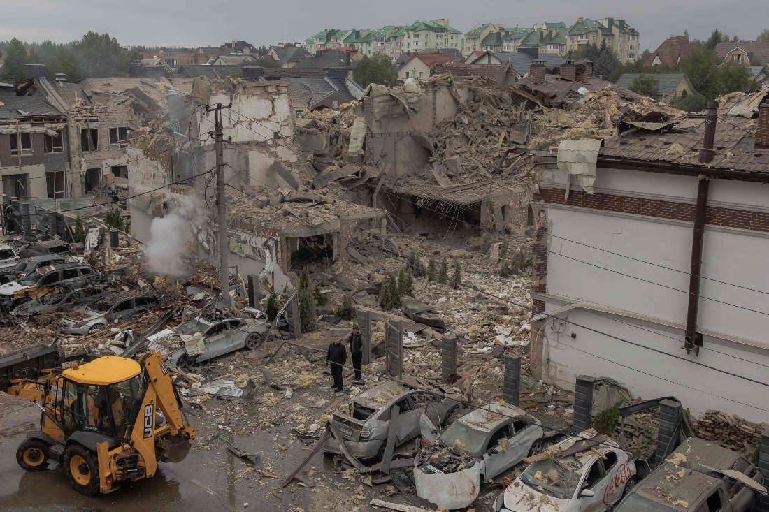 Men stand at the site of heavily damaged residential buildings following a Russian air attack on the outskirts of Kyiv, Ukraine. (AFP)