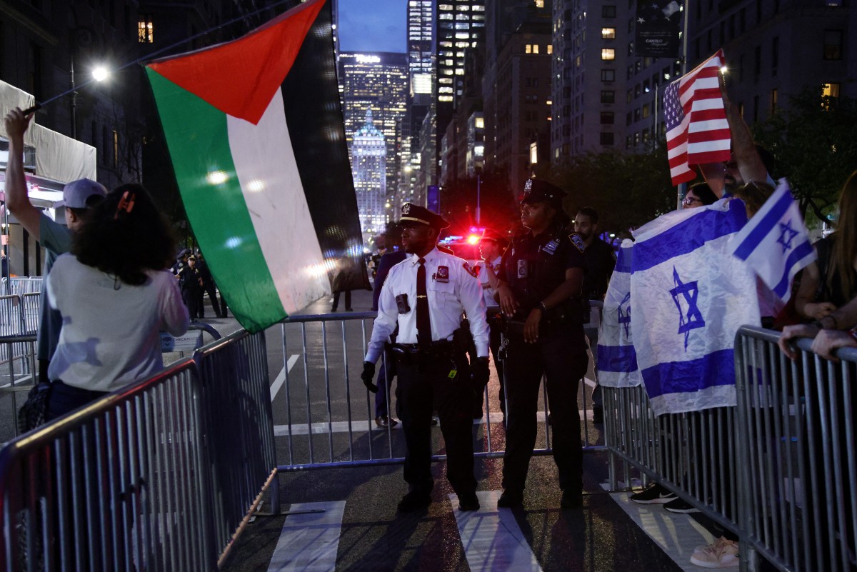 Pro-Palestinian activists wave a Palestinian flag as they take part in a protest in support of Gaza, across from supporters of Israel, outside the hotel of Israel’s Prime Minister Benjamin Netanyahu in New York City, Sept. 25, 2025. (AFP)