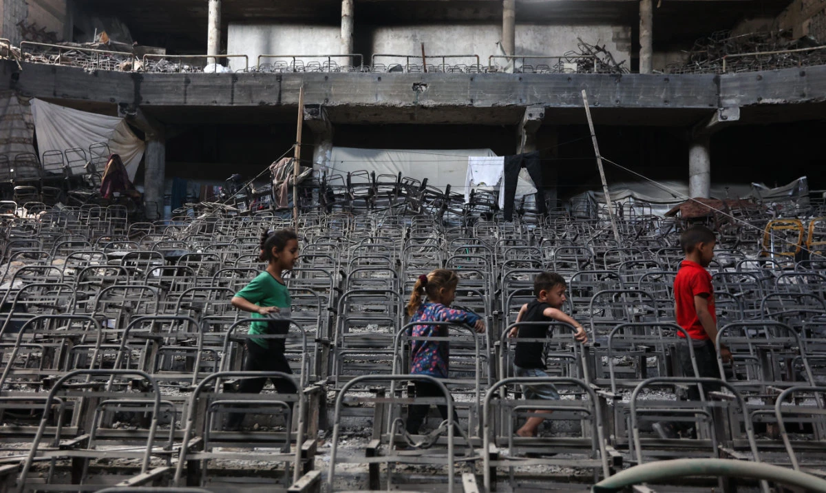 Displaced Palestinian children play at a damaged lecture hall at the Islamic University campus in Gaza City on May 1, 2025. (AFP)