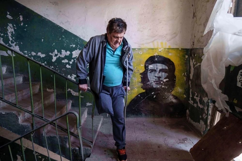 Mykhailo Maistruk, 67, walks downstairs during evacuation from Kostiantynivka, Ukraine, Tuesday. (AP)