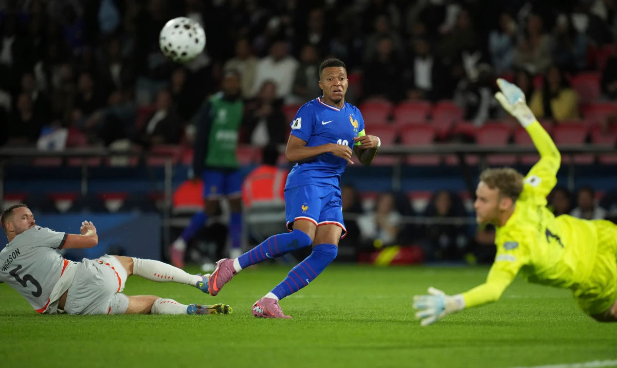 France's Kylian Mbappe, centre, attempts a goal as Iceland goalkeeper Elias Olafsson, right, saves during a World Cup Group D qualifying soccer match between France and Iceland at the Parc des Princes stadium in Paris, Tuesday, Sept. 9, 2025. (AP)