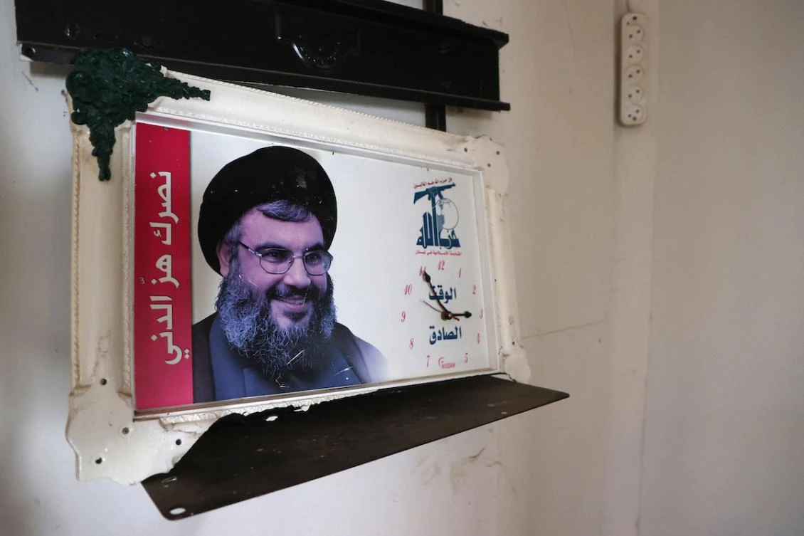 This picture shows a clock bearing the portrait of slain Hezbollah leader Hassan Nasrallah hanging on the wall inside a building reportedly used by Lebanon's Hezbollah group, in the town of in Qusayr in Syria's central Homs province on December 15, 2024. (FILE/AFP)