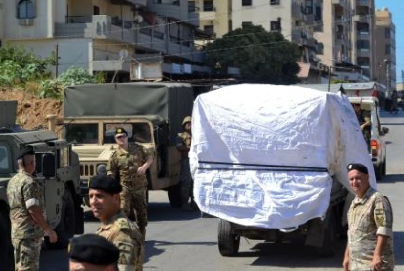 Lebanese army soldiers stand guard as a truck loaded with weapons leaves the Palestinian refugee camp of Beddawi, near the northern city of Tripoli on Sept. 13, 2025. (AFP)