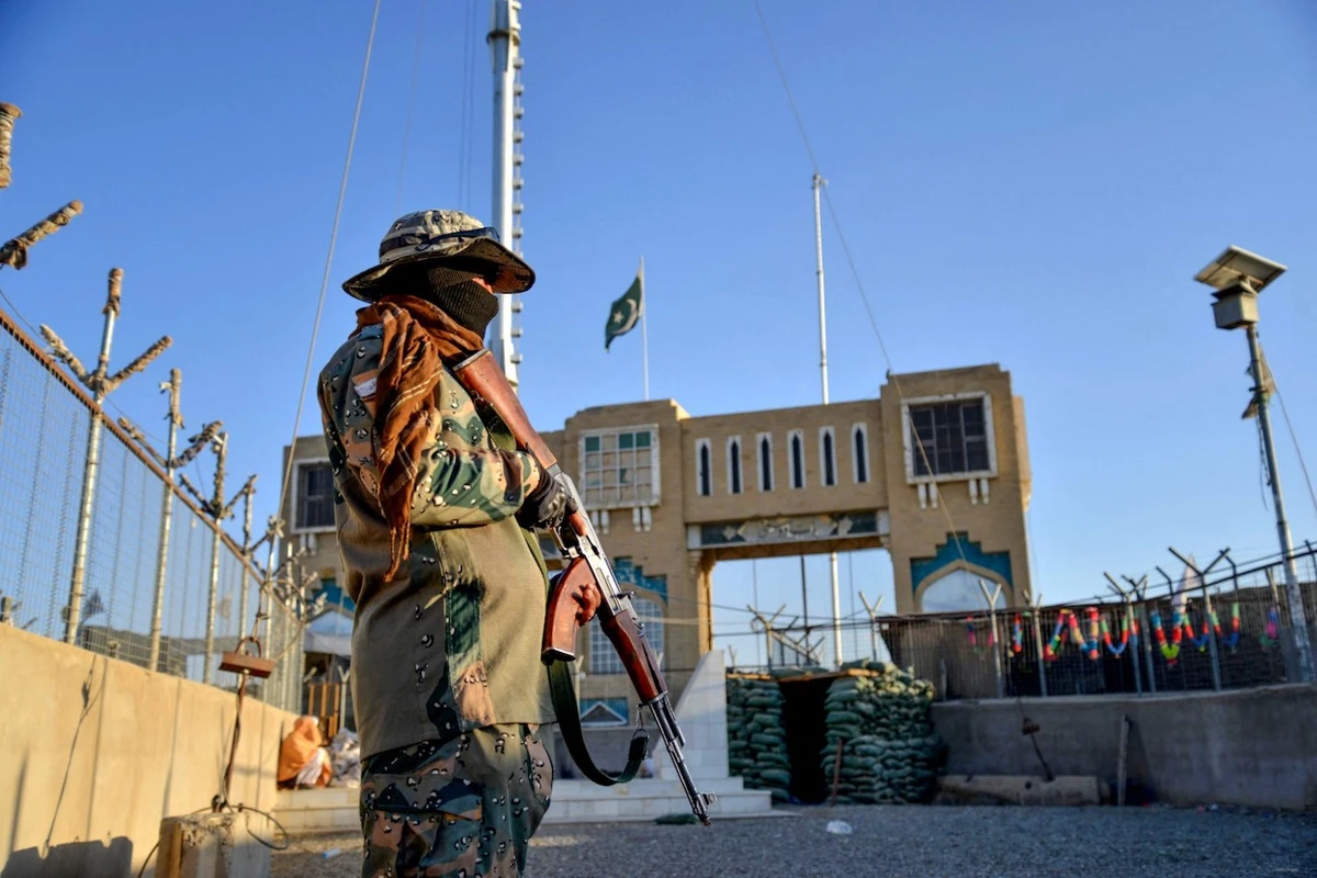 An Afghan security personnel member stands guard at a fenced corridor of the Afghanistan-Pakistan border in Spin Boldak district, Kandahar province. (File/AFP)