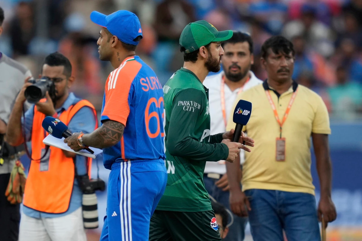 Pakistan's captain Salman Agha, right, walks past India's captain Suryakumar Yadav after the coin toss ahead of the Asia Cup cricket match between India and Pakistan at Dubai International Cricket Stadium on Sept. 14, 2025. (AP)
