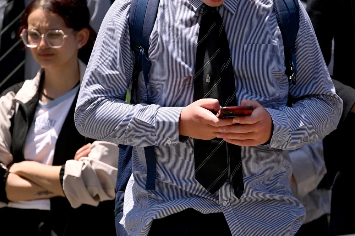 A schoolboy looks at his phone in Melbourne on November 27, 2024 as Australia looks to ban children under 16 from social media with claims social media platforms have been tarnished by cyberbullying, the spread of illegal content, and election-meddling claims.(AFP)