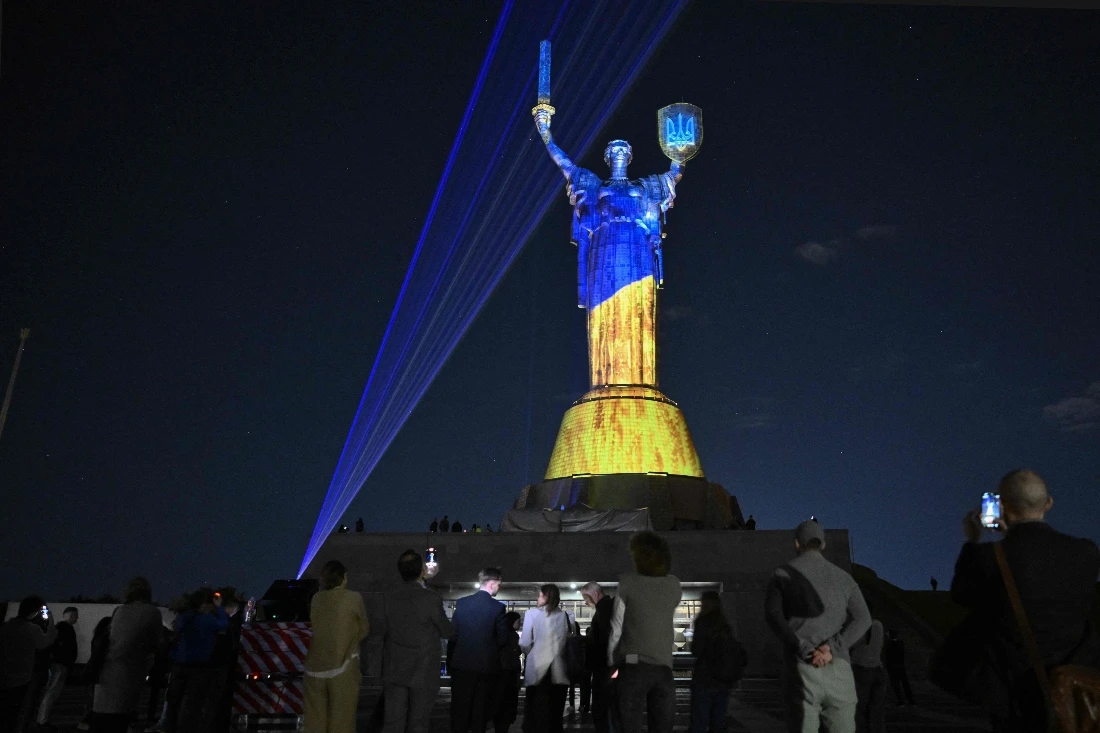 Local residents look at the light installation by Ukrainian artist and lighting designer Mykola Kabluka and the Expolight team on the Motherland Monument in Kyiv, Ukraine. (AFP)