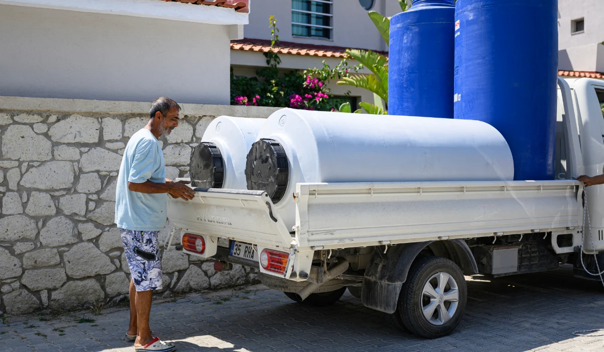 An employee loads water tanks onto a truck to deliver them to hotels in the Turkey west province of Izmir, on July 31, 2025. (AFP)