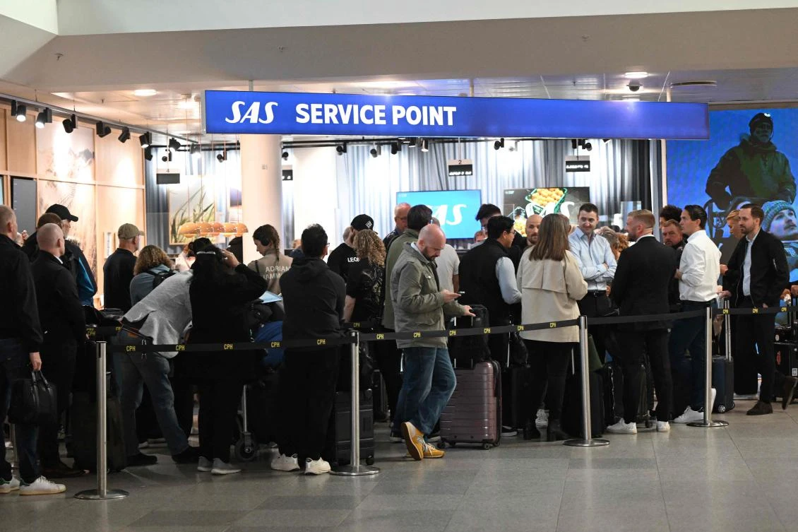 Passengers stand in a queue to get new tickets at the service point of the Copenhagen Airport in Copenhagen, Denmark, on Sept. 23, 2025. (AFP)