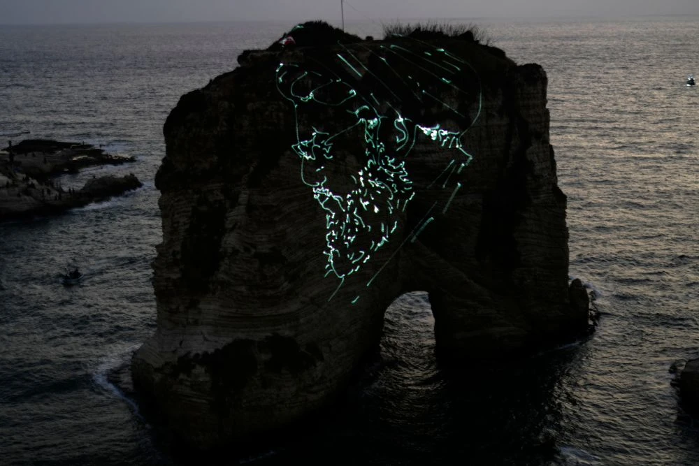 The landmark Raouche Rock is illuminated by a portrait of Hezbollah leader Hassan Nasrallah during an event commemorating his death, Beirut, Lebanon, Thursday, Sept. 25, 2025. (AP Photo)