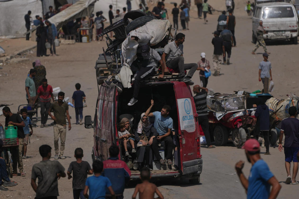 Displaced Palestinians flee northern Gaza by vehicle and on foot, carrying their belongings along the coastal road near Wadi Gaza on Friday. (AP)