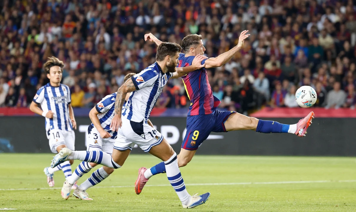 Barcelona's Polish forward #09 Robert Lewandowski fights for the ball with Real Sociedad's Croatian defender #16 Duje Caleta Car during the Spanish league football match between FC Barcelona and Real Sociedad at the Estadi Olimpic Lluis Companys in Barcelona on September 28, 2025. (AFP)