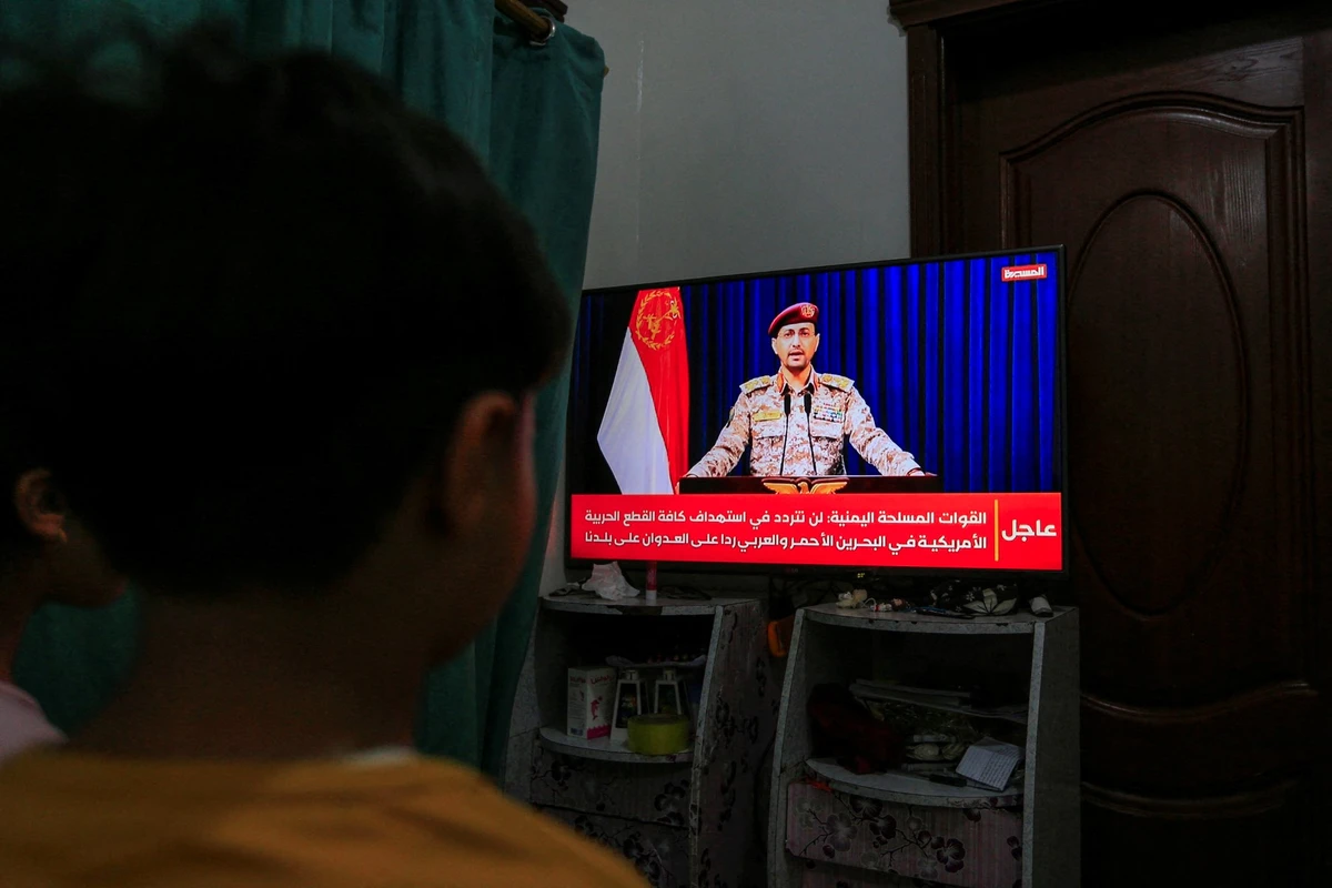 Yemenis in Sanaa watch a statement by Houthi military spokesman Yahya Saree announcing the group launched an attack. (AFP)