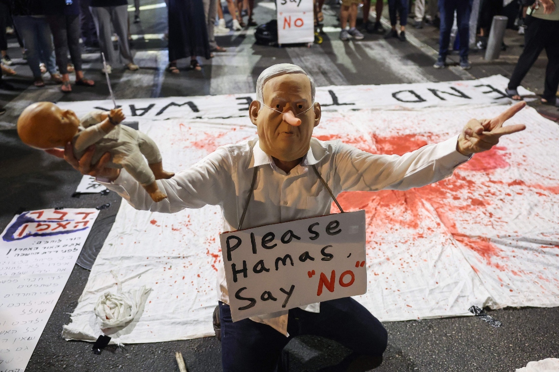 A demonstrator wearing a mask depicting Israel's Premier Benjamin Netanyahu takes part in an installation during an anti-government protest in front of the Likud party building in Tel Aviv, calling for a ceasefire and for action to secure the return of the hostages. (AFP)