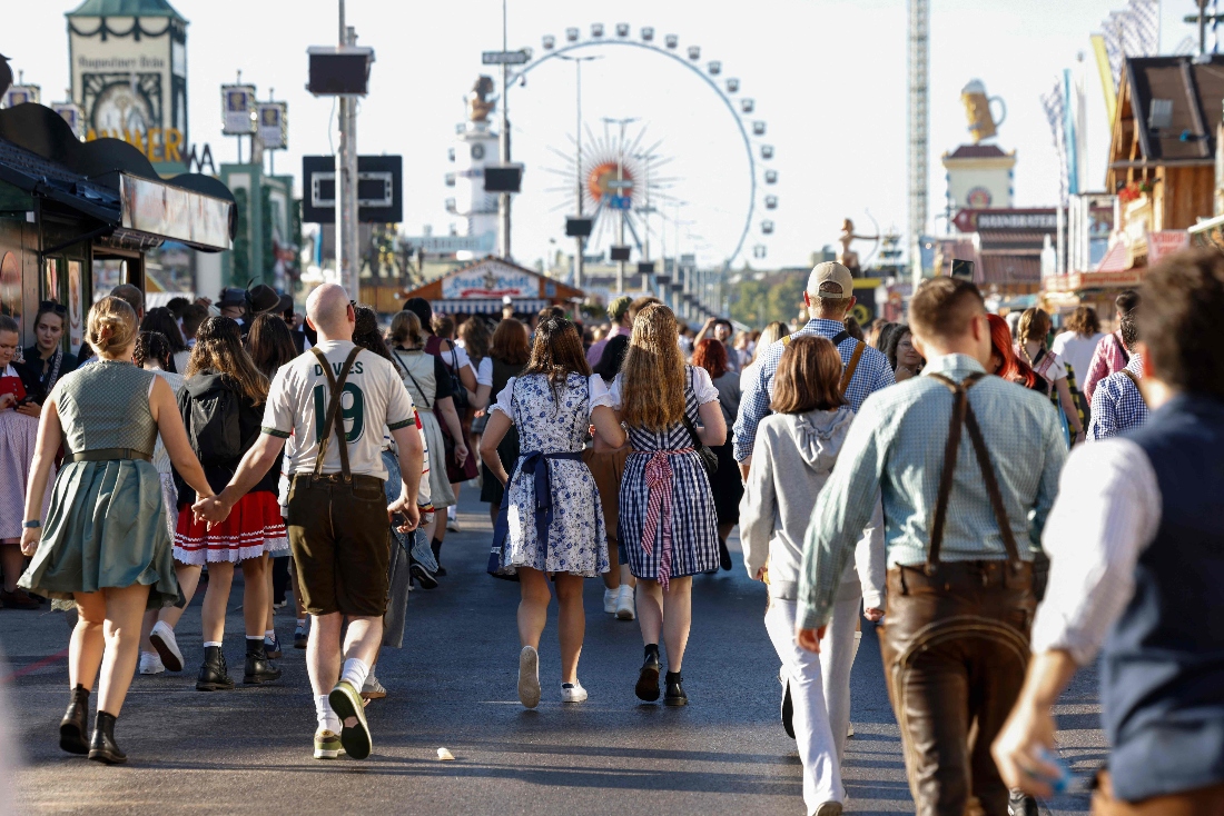Visitors wearing traditional clothes walk at the Theresienwiese fair grounds for the opening of the 190th Oktoberfest beer festival in Munich, southern Germany. (AFP)