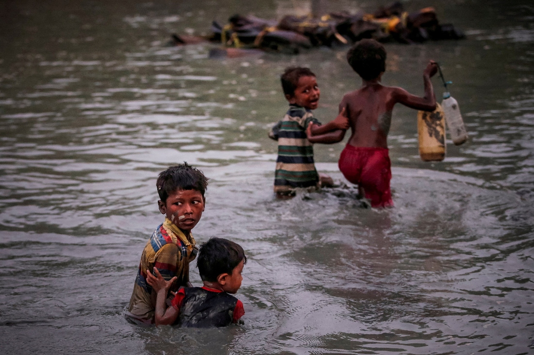Rohingya siblings fleeing violence hold one another as they cross the Naf River along the Bangladesh-Myanmar border in Palong Khali. (Reuters)
