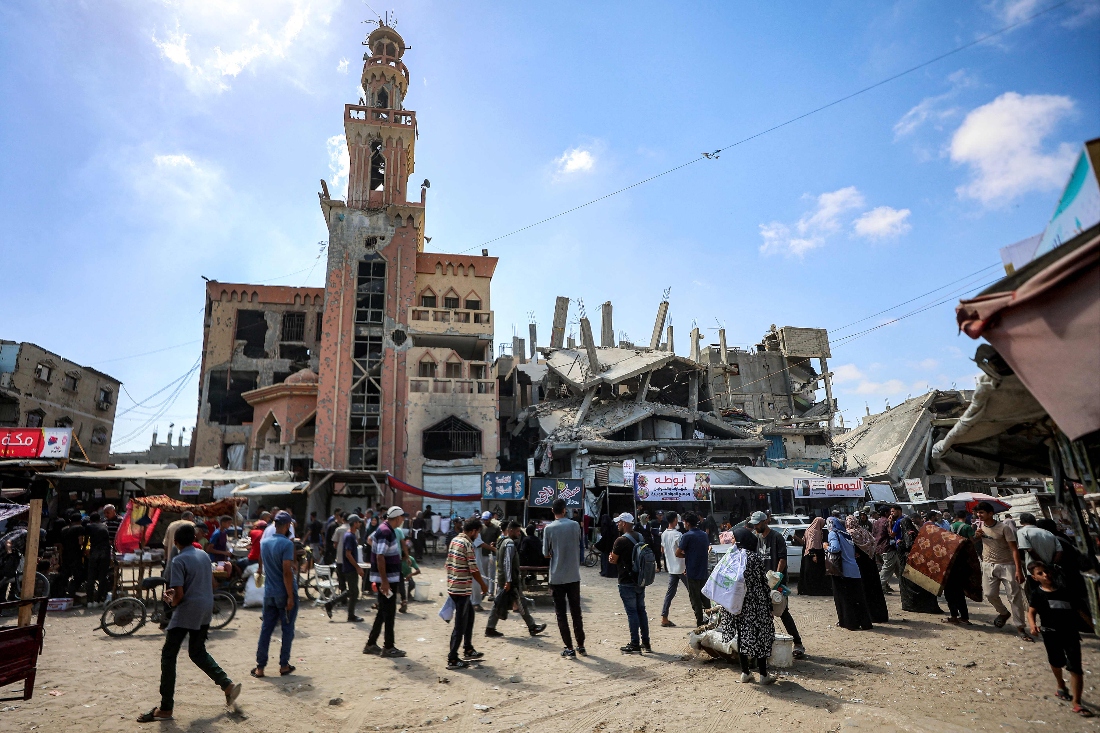 People walk outside the heavily-damaged al-Farouq mosque in Khan Yunis in the southern Gaza Strip. (AFP)