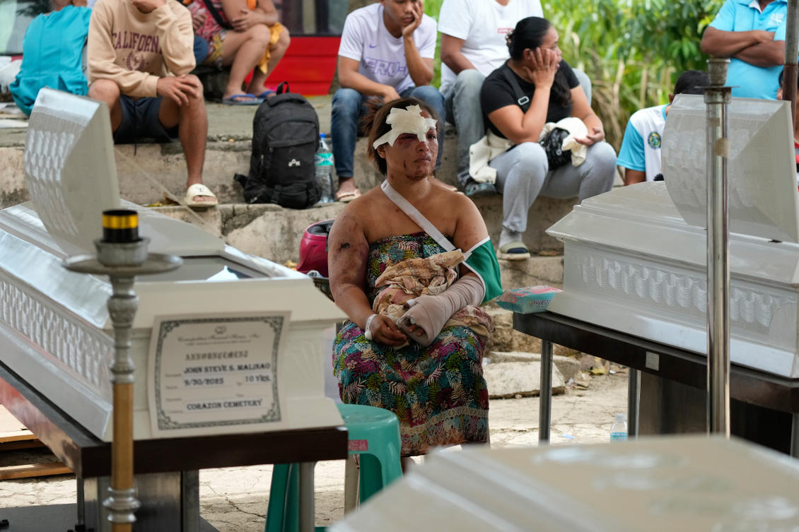 Earthquake survivor Jesiel Malinao sits beside the coffins of her two sons on Thursday, Oct. 2, 2025 after a strong earthquake on Tuesday caused a landslide that toppled their hillside homes in Bogo City, Cebu of central Philippines. (AP)