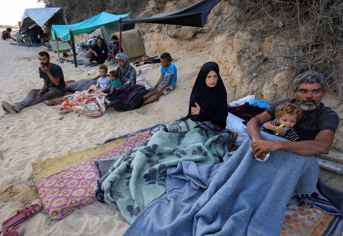 Nancy Abu Matroud shelters by a roadside with her husband Faraj al Ghalayini and their daughter Etra, in the central Gaza Strip. (Reuters)