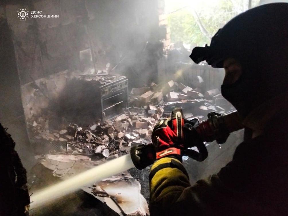 A rescuer puts out a fire of a residential house damaged by a Russian strike on Kherson, Ukraine. (Ukrainian Emergency Service via AP)