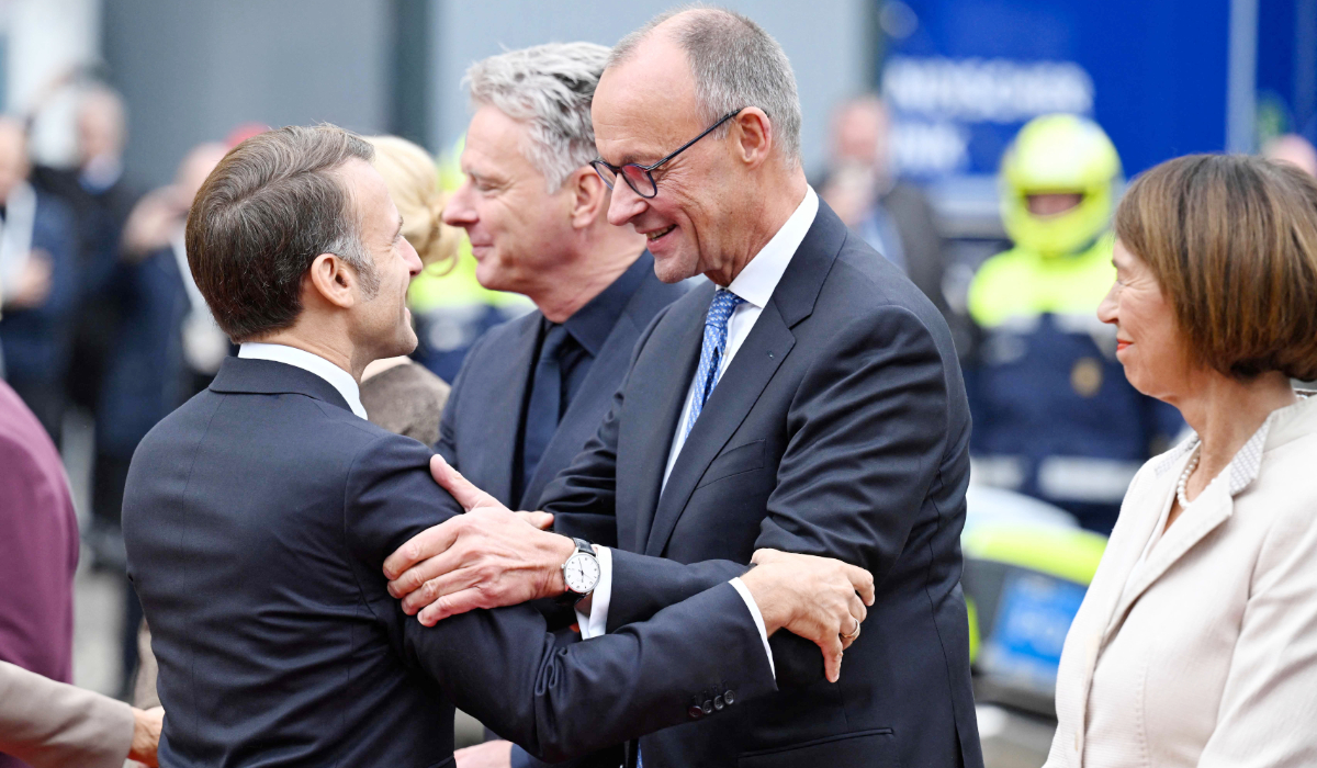 France's President Emmanuel Macron (L) greets German Chancellor Friedrich Merz upon arrival in front of Saarland's State Chancellery during central celebrations on October 3, 2025, the Day of German Unity, in Saarbruecken, southwestern Germany. (AFP)
