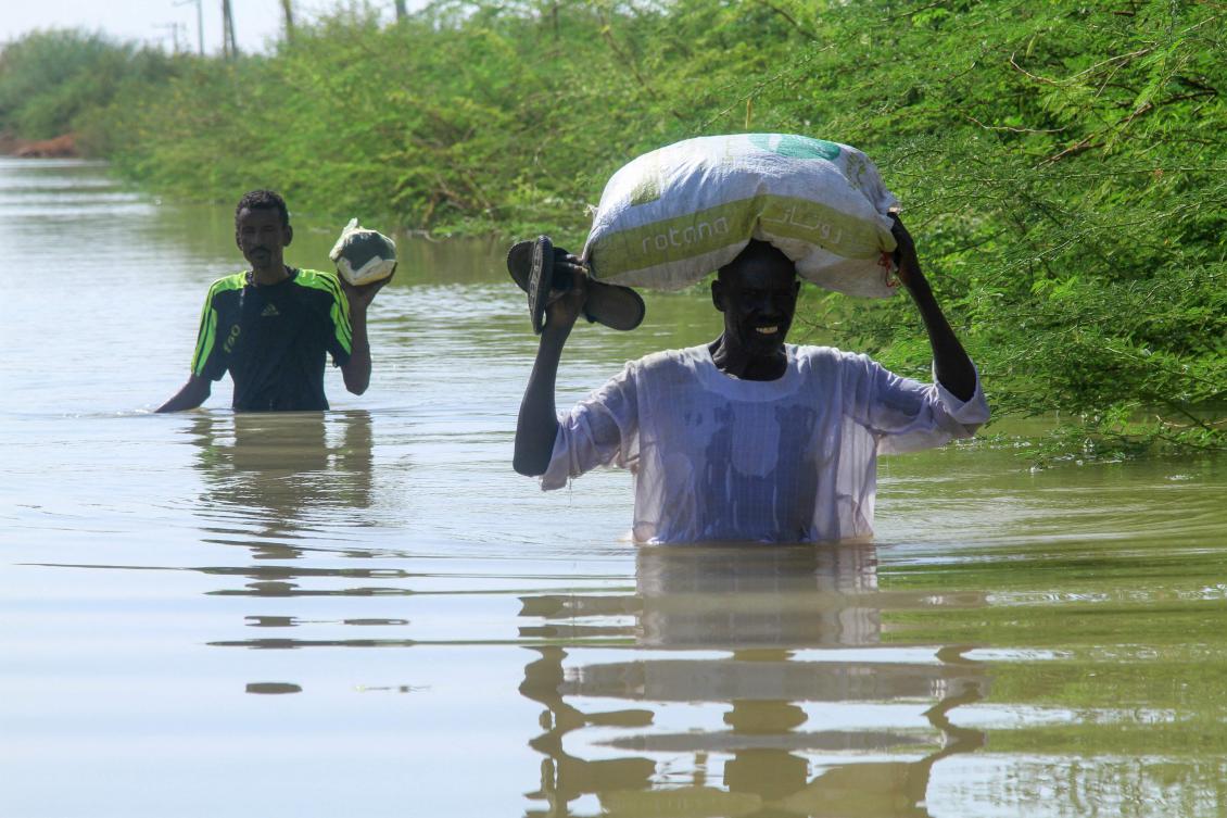 Residents wade through floodwaters from the River Nile as they salvage belongings in the Sudanese village of Wad Ramli north of Khartoum on Wednesday. (AFP)