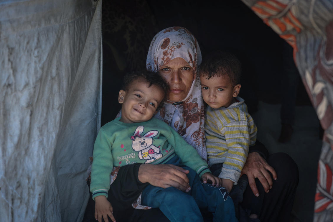 Displaced Palestinian mother Iman Abdel Halim Abu Mutlaq holds her twin sons Uday and Hamza Abu Odah at their tent where they shelter, in Mawasi area, in Khan Younis in the southern Gaza Strip, September 18, 2025. (Reuters)