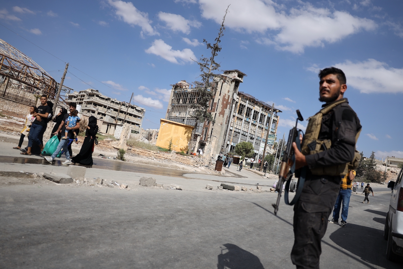 Syrian security forces stand guard as residents leave the Sheikh Maqsoud and Achrafieh neighborhoods of Aleppo, Syria, Tuesday, Oct. 7, 2025. (AP)
