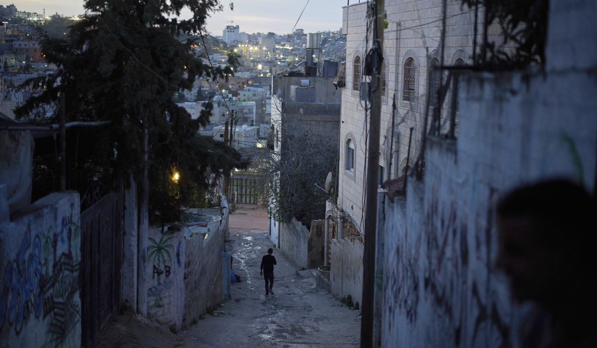 Nasser al-Heimouni, 38, walks down an alley near the spot where his 12-year-old son, Ayman al-Heimouni, was shot by Israeli fire in the West Bank city of Hebron, March 26, 2025. (AP)