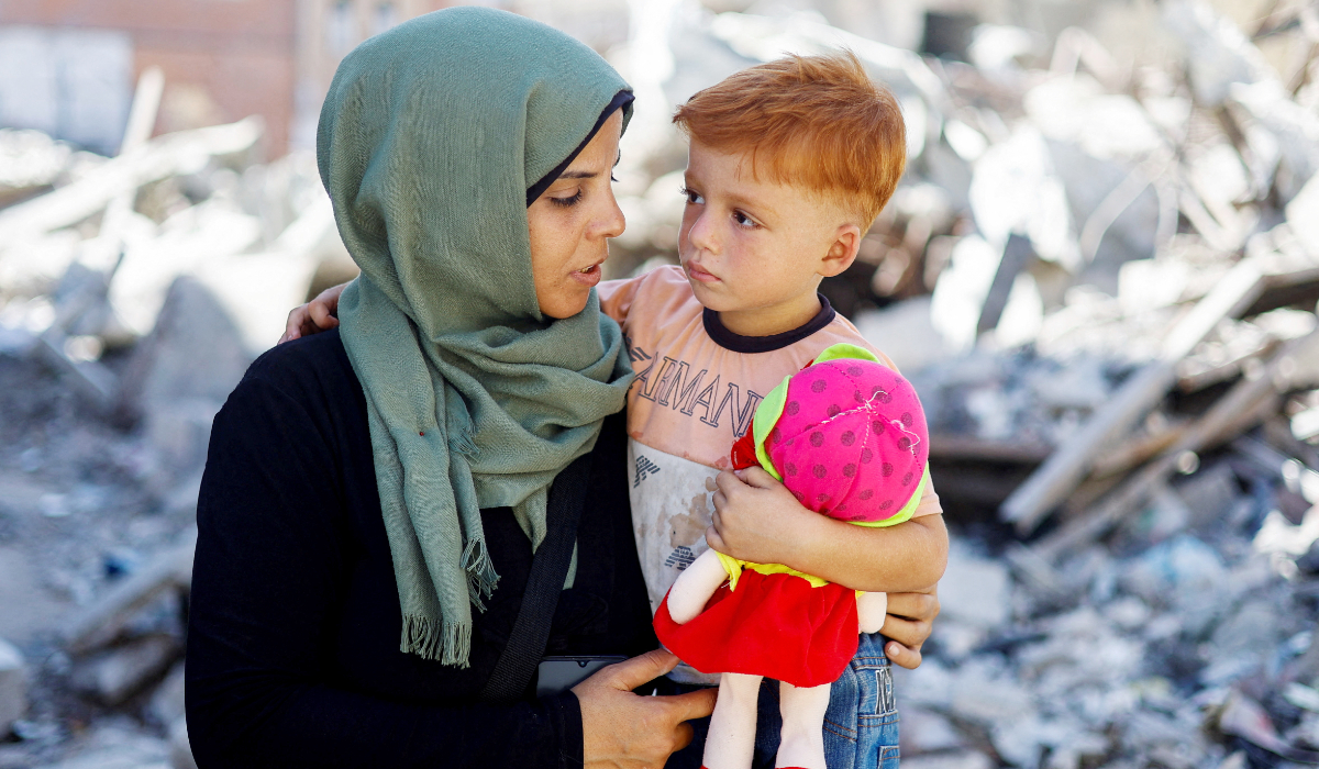 Palestinian woman Inas Abu Maamar, who was photographed at Nasser hospital morgue on October 17 cradling the body of her five-year-old niece Saly, killed in an Israeli strike, sits with her nephew Ahmed, Saly's brother, at the site where Saly was killed, in Khan Younis in the southern Gaza Strip September 11, 2024. (REUTERS)
