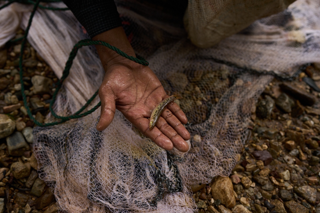 Mahmud Karmar holds a small fish he caught in the river near the Mae La refugee camp in the Tak province of Thailand. (AP)