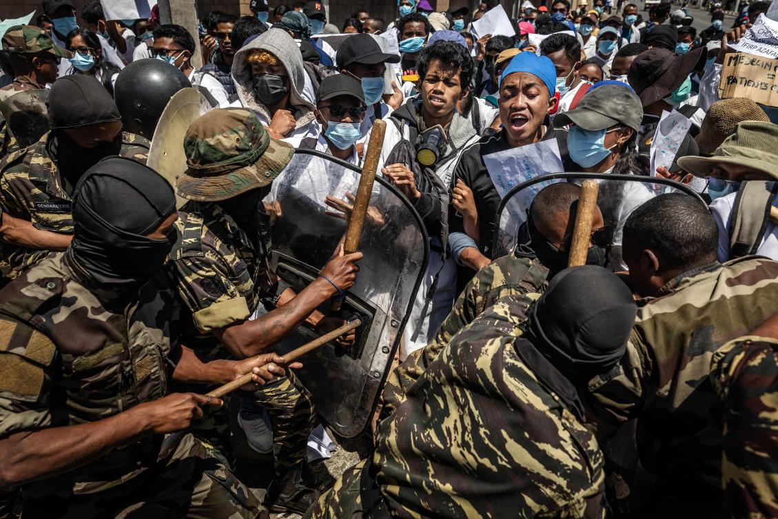 Medical students react as they are pushed with shields and clubs by Malagasy security forces during a demonstration in Antananarivo on Oct. 7, 2025. (AFP)