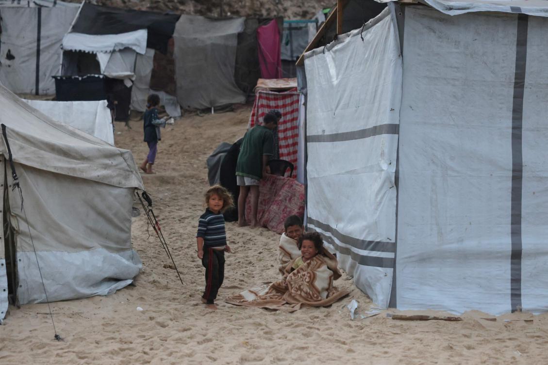 Displaced Palestinians start their day at a makeshift camp by the beach in Al-Zawayda city, near Deir al-Balah, in the central Gaza Strip on October 9, 2025, following an overnight announcement of a ceasefire deal between Hamas and Israel to be signed in Egypt. (AFP)