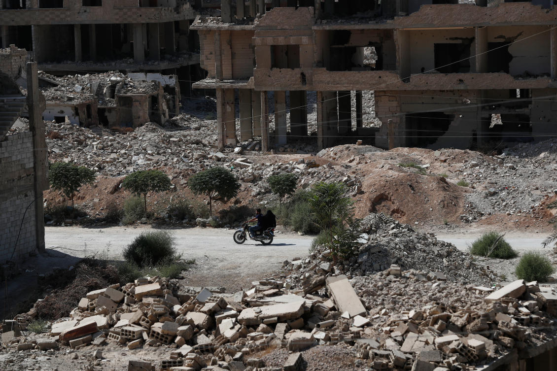 A couple rides a motorcycle past destroyed buildings in Ein Tarma, Monday, Oct. 6, 2025, a suburb of Damascus that was heavily bombed by forces loyal to Syrian President Bashar Assad during the war in Syria. (AP)
