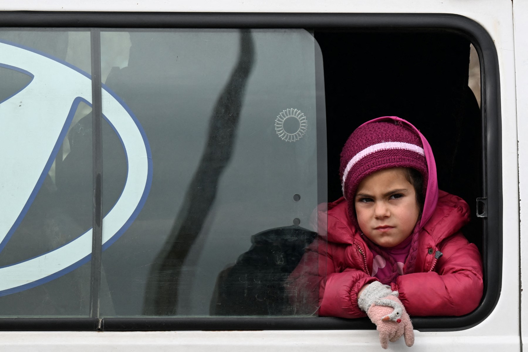 A Syrian child from a displaced family looks out of the window of a bus carrying them back from northern Syria to Homs in central Syria, Feb. 10, 2025. (AFP)