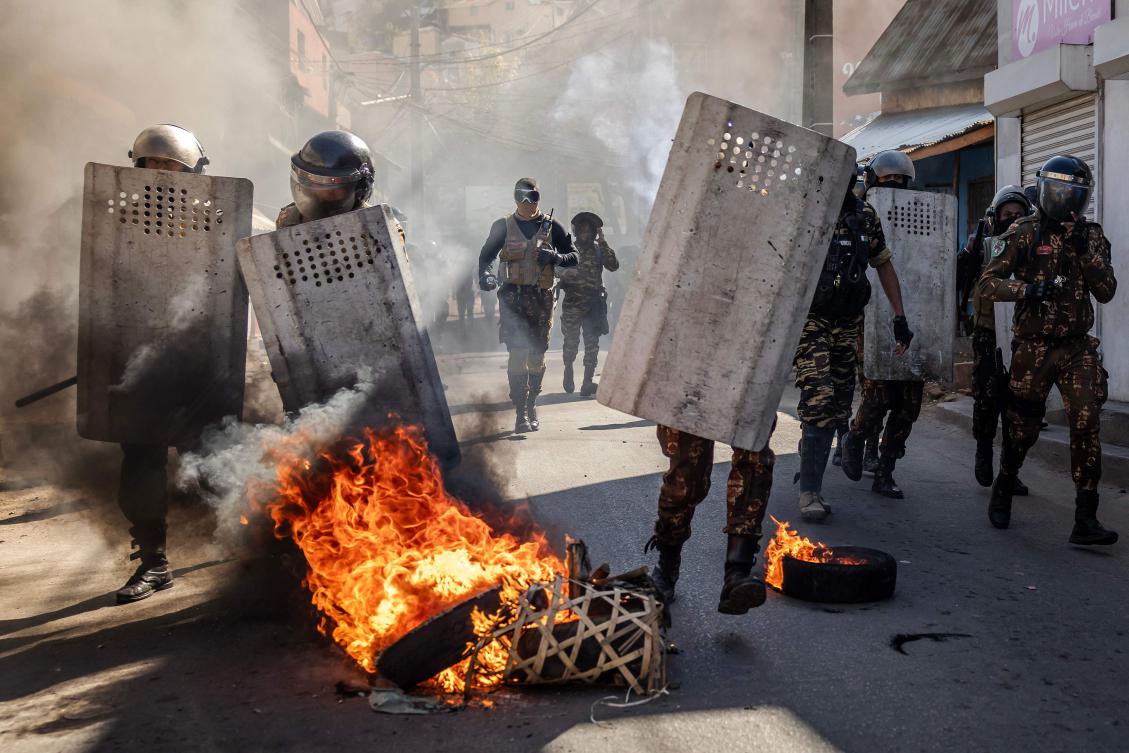 Malagasy police officers run to push back protesters during clashes at a demonstration calling for the resignation of President Andry Rajoelina, in Antananarivo, on Oct. 6, 2025. (AFP)