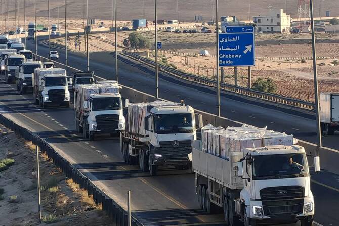 A convoy of Jordanian trucks loaded with humanitarian aid and destined for the Gaza Strip, driving on a road in Jordan toward the Israeli military post in the Zikim area. (AFP/File Photo)