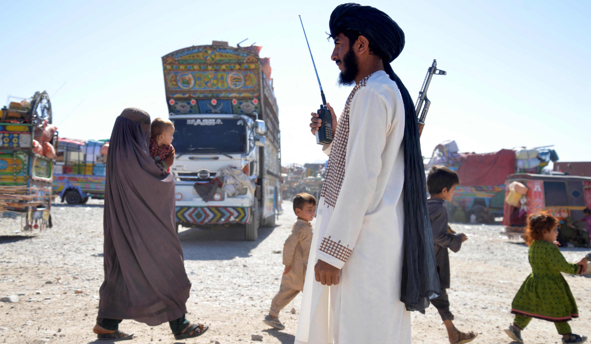 A Taliban security personnel stands guard as Afghans deported from Pakistan arrive at a registration centre at Takhta Pul in Kandahar province on October 9, 2025. (AFP)