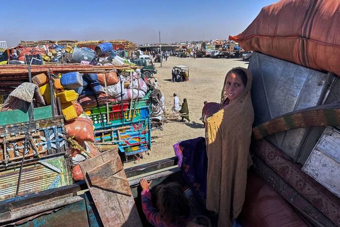 Afghan refugee girls sit over a truck loaded with their belongings as they, along with others, wait for the opening of the border crossing point, which closed following Afghan and Pakistani security forces exchanging cross-border firing, at a camp in Chaman, Pakistan on October 12, 2025. (AP)