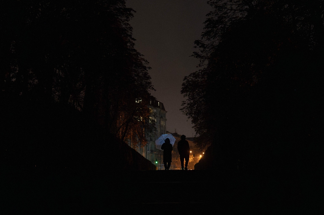 People walk down the street with umbrellas during a power outage in Kyiv, Ukraine. (AFP)