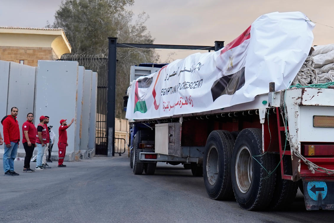 Egyptian Red Crecent members monitor trucks carrying humanitarian aids as they enter the Rafah crossing between Egypt and the Gaza Strip, Oct. 12, 2025. (AP Photo/Mohamed Arafat)